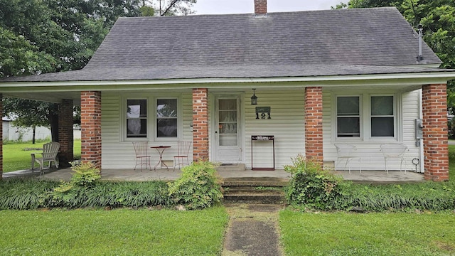 121 W 5th St, Rector, AR 72461 - bungalow-style home featuring covered porch, a shingled roof, a chimney, and a front lawn