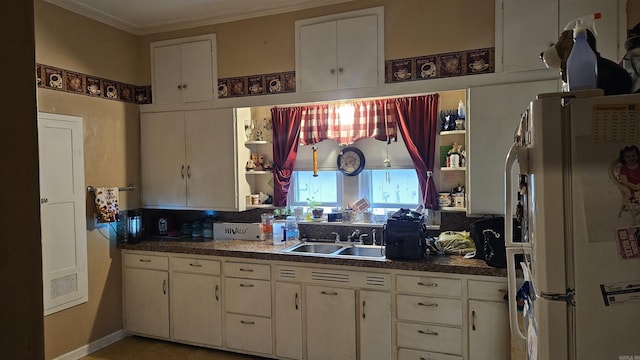 121 W 5th St, Rector, AR 72461 - kitchen with freestanding refrigerator, open shelves, white cabinetry, ornamental molding, and dark countertops