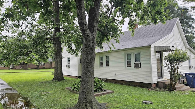 121 W 5th St, Rector, AR 72461 - back of house with a lawn, cooling unit, a shingled roof, and a chimney