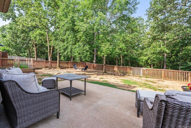 181 Diamond Pointe Dr, Maumelle, AR 72113 - fenced backyard with a patio, outdoor dining area, and view of scattered trees
