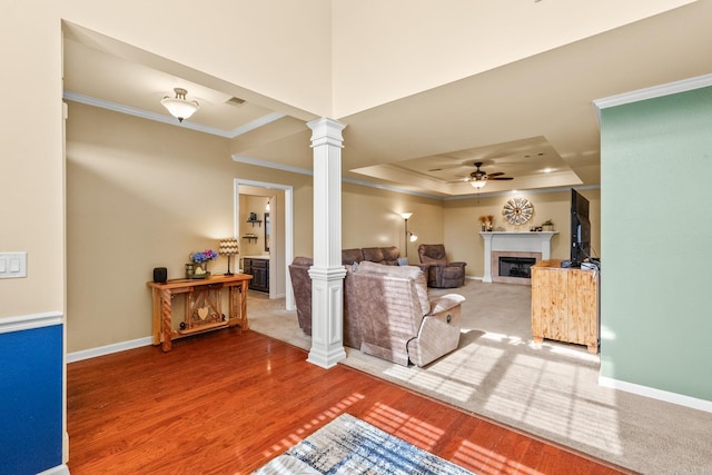 181 Diamond Pointe Dr, Maumelle, AR 72113 - living room with ornate columns, crown molding, a ceiling fan, a fireplace, and a tray ceiling