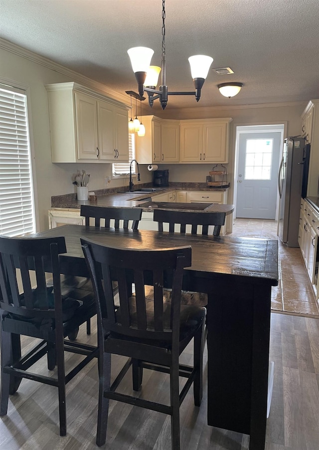 497 Law 611, Walnut Ridge, AR 72476 - kitchen featuring crown molding, freestanding refrigerator, a textured ceiling, dark countertops, and decorative light fixtures