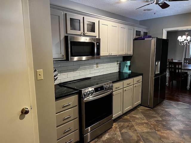 39 Dike View Dr, Heber Springs, AR 72543 - kitchen with appliances with stainless steel finishes, dark countertops, ceiling fan, decorative backsplash, and a textured ceiling
