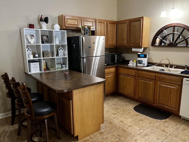 39 Dike View Dr, Heber Springs, AR 72543 - kitchen featuring freestanding refrigerator, dark countertops, brown cabinets, light tile patterned flooring, and a breakfast bar