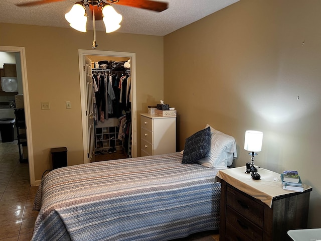 39 Dike View Dr, Heber Springs, AR 72543 - bedroom featuring tile patterned floors, a walk in closet, a closet, ceiling fan, and a textured ceiling