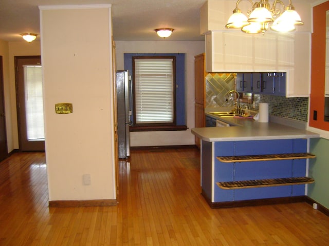 405 Fairway Dr, Horseshoe Bend, AR 72512 - kitchen featuring hardwood / wood-style flooring, backsplash, freestanding refrigerator, and a chandelier