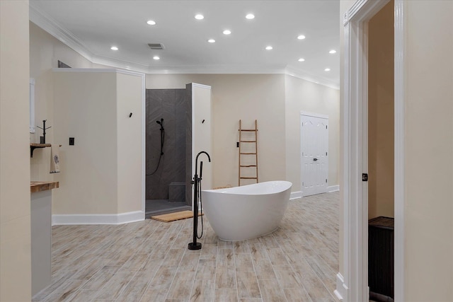 15355 Pleasant Grove Ln, Harrisburg, AR 72432 - full bathroom featuring ornamental molding, walk in shower, a freestanding tub, wood finished floors, and recessed lighting