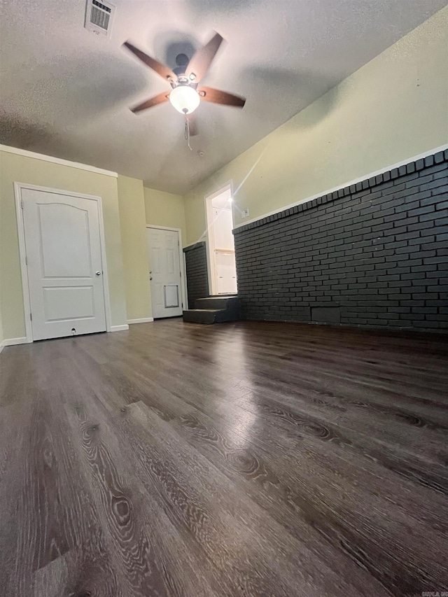1505 W Park Ave, Searcy, AR 72143 - unfurnished living room with ceiling fan, wood finished floors, brick wall, and a textured ceiling