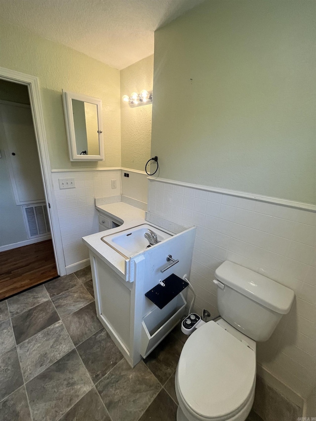1505 W Park Ave, Searcy, AR 72143 - half bathroom featuring wainscoting, vanity, and a textured ceiling