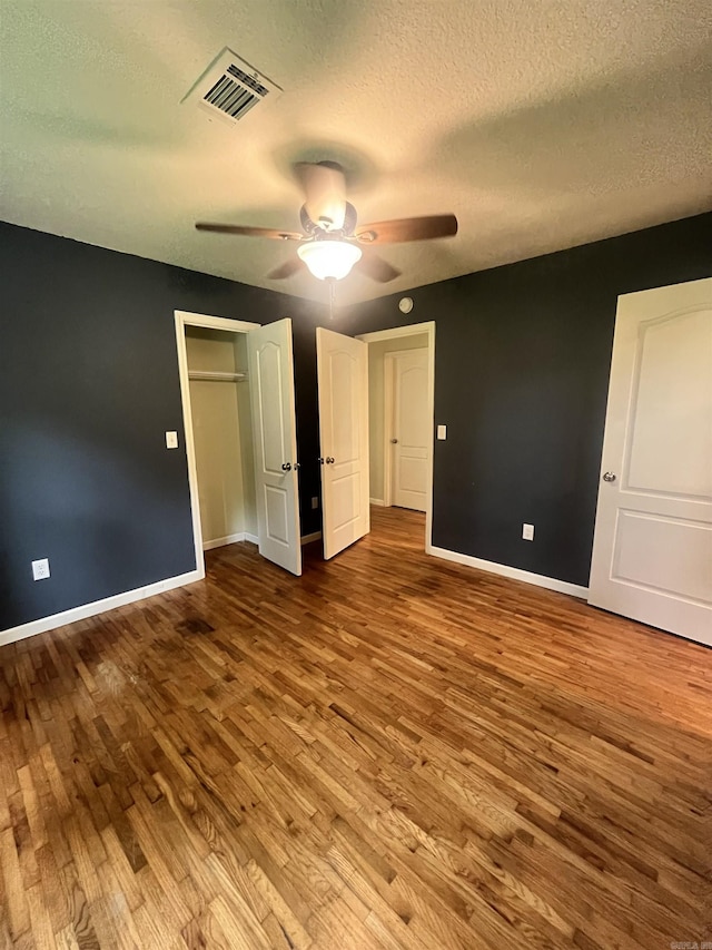 1505 W Park Ave, Searcy, AR 72143 - unfurnished bedroom featuring wood finished floors, a textured ceiling, ceiling fan, and a closet