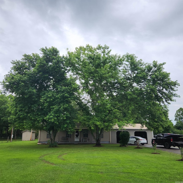 128 Reed Wade Rd, Batesville, AR 72501 - view of grassy yard featuring a garage, a storage shed, and a porch
