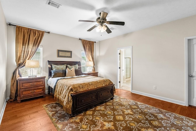 bedroom with wood finished floors, connected bathroom, and a ceiling fan