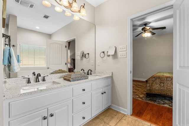 ensuite bathroom featuring double vanity, a ceiling fan, and wood finished floors