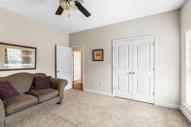 carpeted living area featuring ceiling fan and baseboards