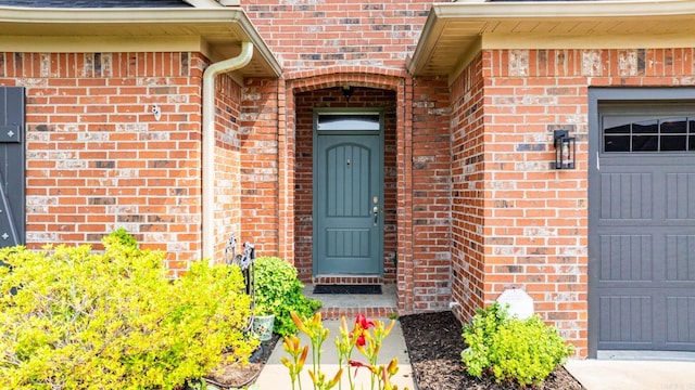 property entrance featuring brick siding and a garage