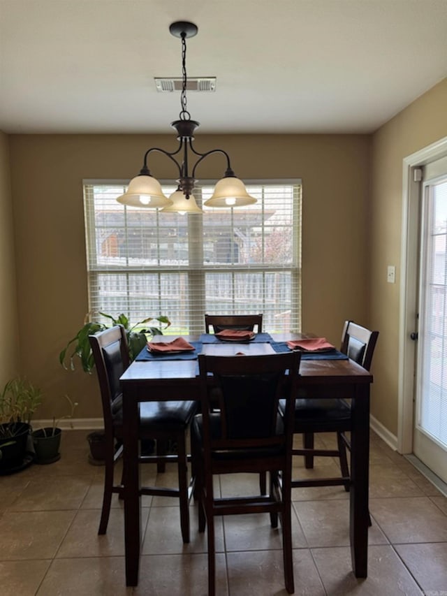 tiled dining space featuring baseboards