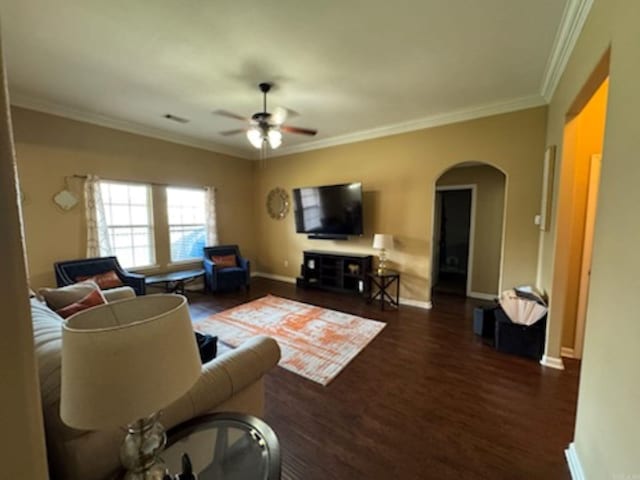 living area with arched walkways, ceiling fan, wood finished floors, and ornamental molding
