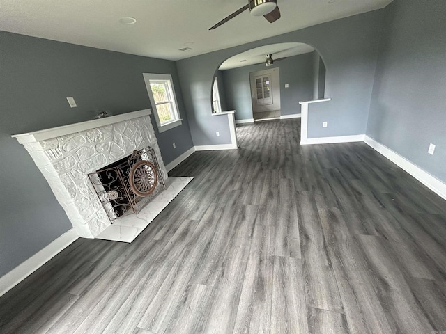 261 E Military, North Little Rock, AR 72118 - unfurnished living room with a ceiling fan, arched walkways, dark wood-style flooring, and a tiled fireplace