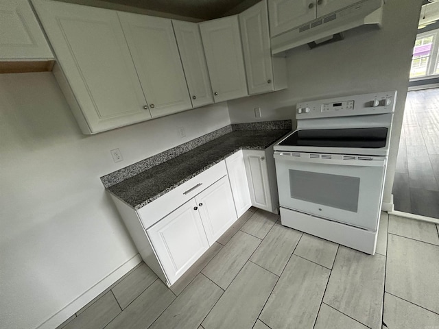 261 E Military, North Little Rock, AR 72118 - kitchen featuring white electric stove, extractor fan, wood tiled floors, dark countertops, and white cabinets
