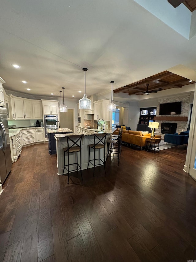 350 Wellesley, Conway, AR 72034 - kitchen featuring a kitchen breakfast bar, dark wood-style flooring, recessed lighting, stainless steel appliances, and a fireplace