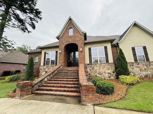350 Wellesley, Conway, AR 72034 - view of front of house with stone siding, french doors, stucco siding, roof with shingles, and a front lawn