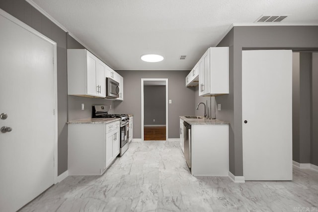 2911 Wynne Dr, Little Rock, AR 72204 - kitchen with stainless steel appliances, light marble finish floors, and white cabinets