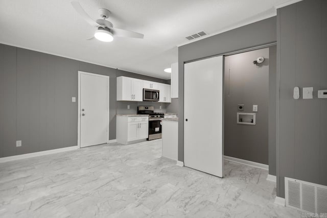 2911 Wynne Dr, Little Rock, AR 72204 - kitchen with stainless steel appliances, a ceiling fan, light marble finish flooring, light countertops, and white cabinetry