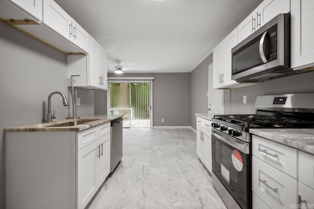 2911 Wynne Dr, Little Rock, AR 72204 - kitchen featuring stainless steel appliances, light marble finish floors, light stone counters, white cabinetry, and ceiling fan