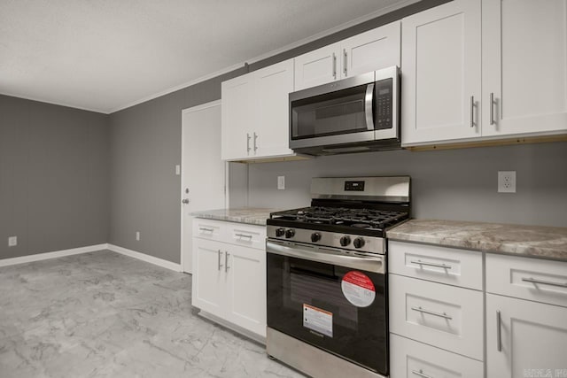 2911 Wynne Dr, Little Rock, AR 72204 - kitchen featuring appliances with stainless steel finishes, white cabinets, light marble finish floors, and ornamental molding