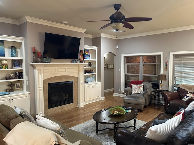 2205 Vermont St, Conway, AR 72034 - living room with wood finished floors, arched walkways, ornamental molding, a ceiling fan, and a fireplace