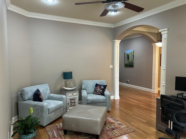 2205 Vermont St, Conway, AR 72034 - sitting room with decorative columns, ceiling fan, crown molding, arched walkways, and wood finished floors