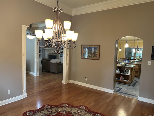 2205 Vermont St, Conway, AR 72034 - unfurnished dining area featuring a chandelier, arched walkways, ornamental molding, and wood finished floors