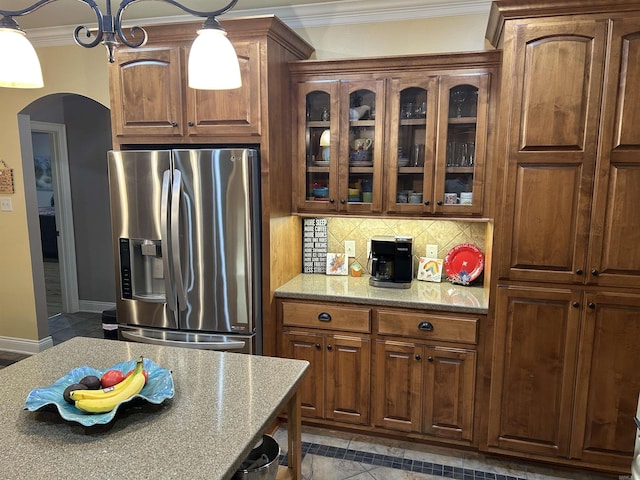 2205 Vermont St, Conway, AR 72034 - kitchen with stainless steel fridge, arched walkways, crown molding, glass insert cabinets, and light stone countertops