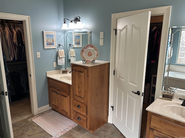 2205 Vermont St, Conway, AR 72034 - bathroom with two vanities, a spacious closet, and a bathtub