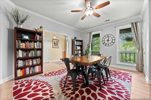 113 Friendship Ln, Beebe, AR 72012 - dining space featuring light wood-style flooring, ceiling fan, a textured ceiling, and crown molding