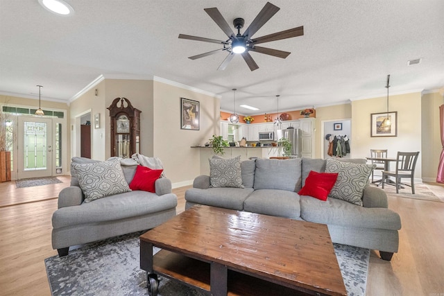 113 Friendship Ln, Beebe, AR 72012 - living area with light wood finished floors, a textured ceiling, a ceiling fan, and ornamental molding