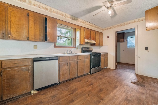 27 Arbor Oaks Dr, Sherwood, AR 72120 - kitchen featuring appliances with stainless steel finishes, under cabinet range hood, a textured ceiling, light countertops, and brown cabinets