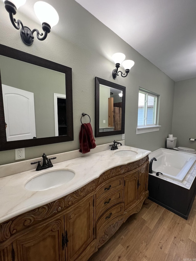 5942 Joey Ln, Texarkana, AR 71854 - bathroom featuring double vanity, wood finished floors, and a bath