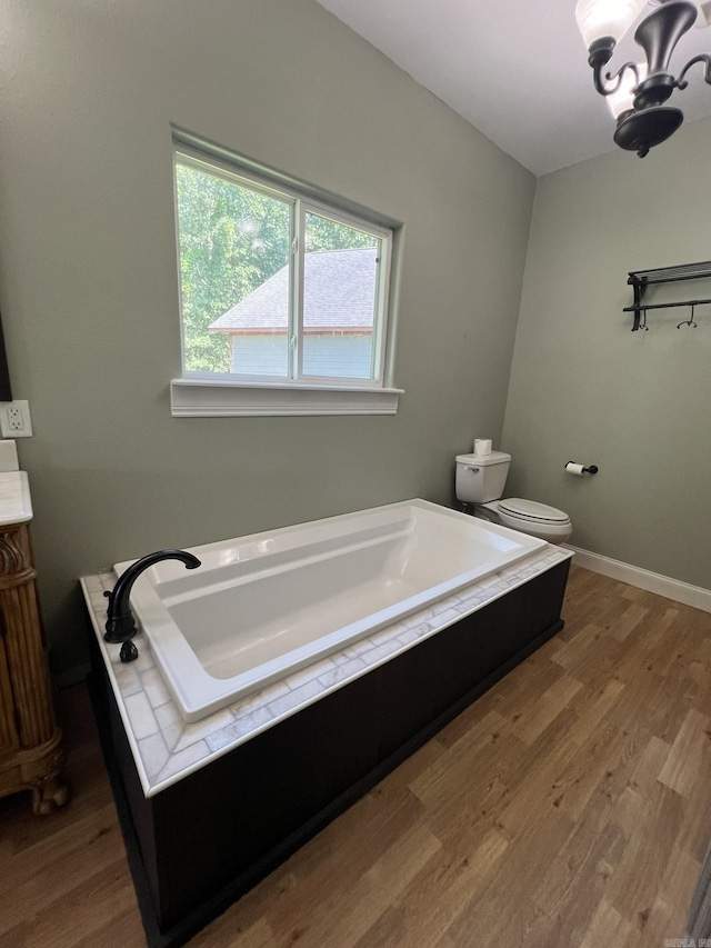5942 Joey Ln, Texarkana, AR 71854 - bathroom featuring a bath, wood finished floors, vanity, and a chandelier