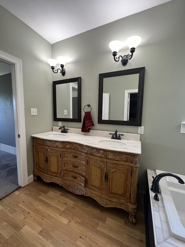 5942 Joey Ln, Texarkana, AR 71854 - bathroom featuring double vanity, wood finished floors, and a tub