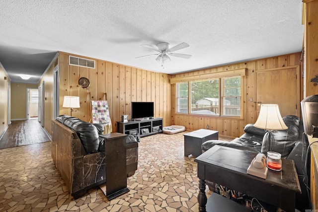 1903 W Arch Ave, Searcy, AR 72143 - living room with a ceiling fan, wooden walls, stone finish floors, crown molding, and a textured ceiling