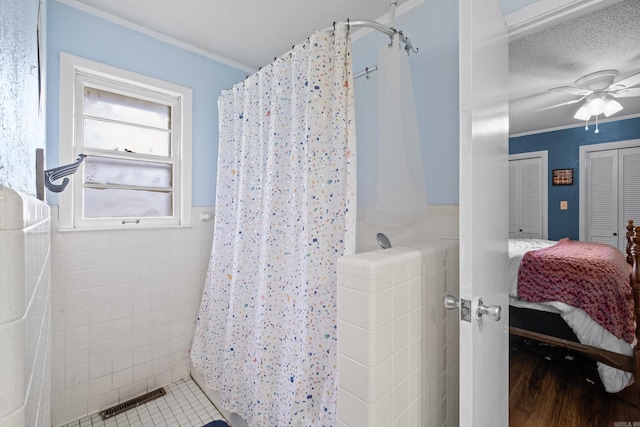 1903 W Arch Ave, Searcy, AR 72143 - ensuite bathroom featuring tile walls, a shower with curtain, ornamental molding, a ceiling fan, and wainscoting