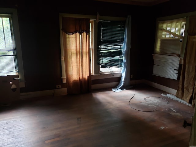 1504 W 18th Ave, Pine Bluff, AR 71603 - empty room featuring healthy amount of natural light and wood finished floors