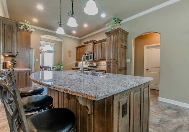 2148 Avondale Dr, Benton, AR 72019 - kitchen featuring stainless steel microwave, arched walkways, light stone countertops, a center island with sink, and crown molding