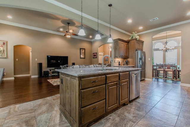 2148 Avondale Dr, Benton, AR 72019 - kitchen with arched walkways, appliances with stainless steel finishes, an island with sink, light stone countertops, and crown molding