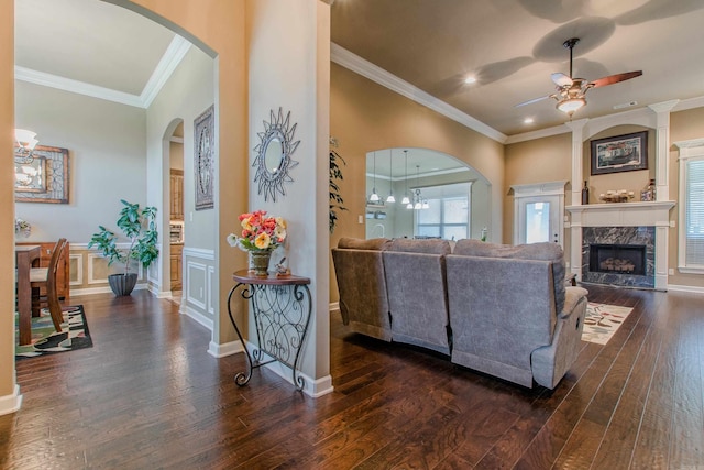 2148 Avondale Dr, Benton, AR 72019 - living area featuring ceiling fan, arched walkways, dark wood-style flooring, a fireplace, and crown molding