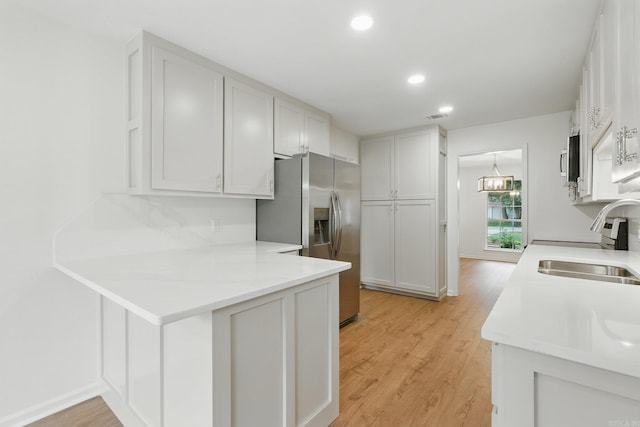 6 Eve Ln, Conway, AR 72034 - kitchen featuring appliances with stainless steel finishes, a peninsula, light wood finished floors, light countertops, and recessed lighting
