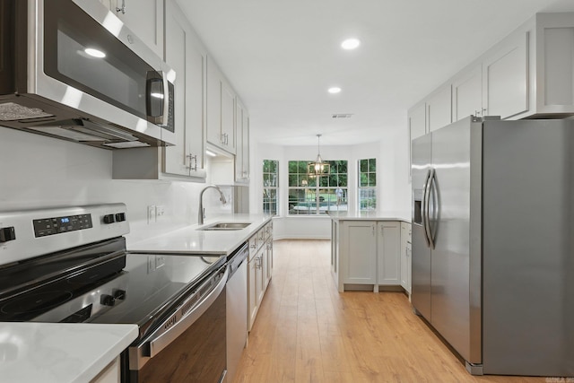 6 Eve Ln, Conway, AR 72034 - kitchen featuring stainless steel appliances, light wood-style flooring, light countertops, recessed lighting, and hanging light fixtures