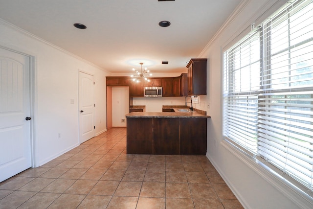 1206 Ryan Ln, Paragould, AR 72450 - kitchen with stainless steel microwave, a peninsula, a chandelier, healthy amount of natural light, and ornamental molding