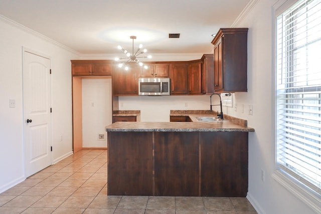 1206 Ryan Ln, Paragould, AR 72450 - kitchen featuring stainless steel microwave, a peninsula, a chandelier, healthy amount of natural light, and crown molding
